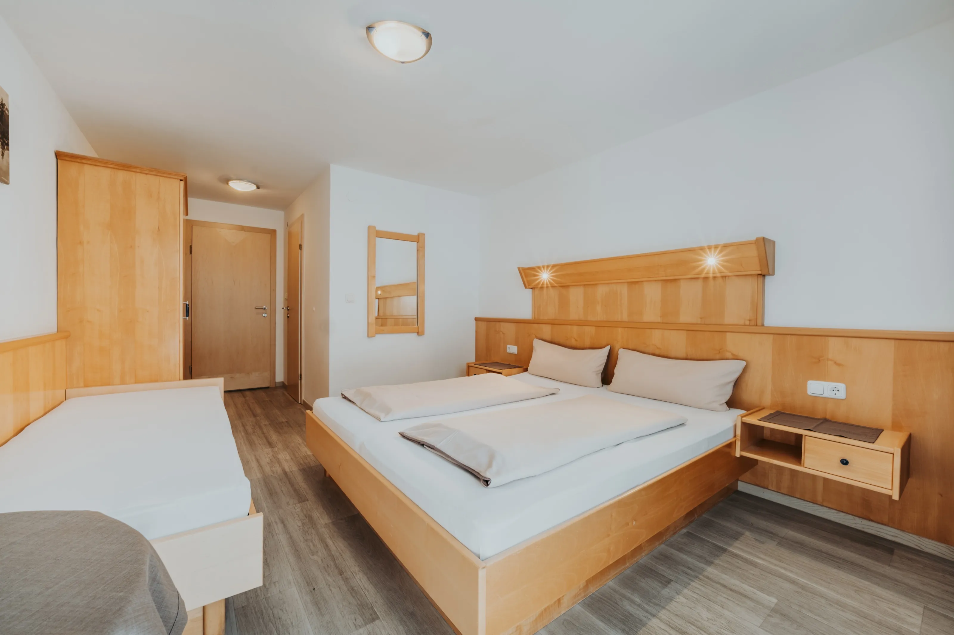 Zweiter Schlafraum mit Doppelbett, Einzelbett und Kleiderschrank.